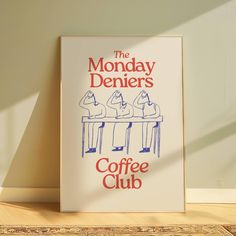 the monday deniers coffee club poster is displayed on a table in front of a wall