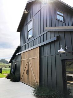 a barn with an open garage door and large windows on the side of the building