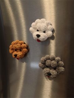 four crocheted animals are placed on a metallic surface