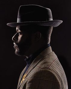 a man in a suit and hat looking off to the side