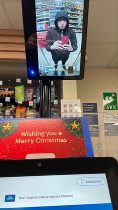 a cell phone sitting on top of a stand in front of a tv screen with the message wishing you a merry christmas