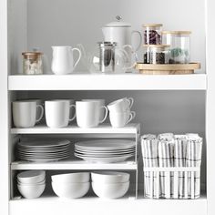 white dishes and cups on shelves in a kitchen