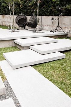 concrete steps are arranged in the middle of a grassy area with chairs and lights on them