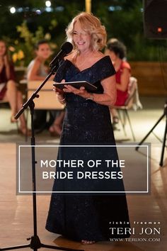 a woman standing in front of a microphone and holding a book with the words mother of the bride dresses on it