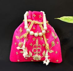 Grab our Exclusive Pink Designer Zardosi Work Potli Bag With Drawstring Pattern and Tassels  Made by Indian Artisans Made up of premium material This potli, which combines traditional and modern embroidery work, looks great with both Indian and Western attire. It is perfect for weddings and festive occasions. It would be the perfect complement to your designer saree, lehanga, or any type of dress.  It can hold all of your essentials and accessories, making it a great gift for any woman. Drawstring Pattern  Compartment : 1 compartment Spacious Color : Pink  Pearl Cord Dimensions : 9" X 9" Disclaimer :  Product color may slightly vary due to photogenic effect. Women's Bags By Style, Potli Bags, Online Pattern, Modern Embroidery, Pink Pearl, Types Of Dresses, Wedding Anniversary Gifts, Pink Bag, Saree Designs