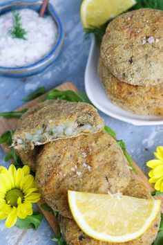 some food on a plate with lemons and flowers