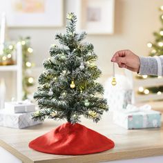 a small christmas tree is being held by someone's hand with a key in it