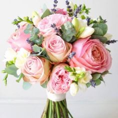 a bouquet of pink and white flowers sitting on top of a table