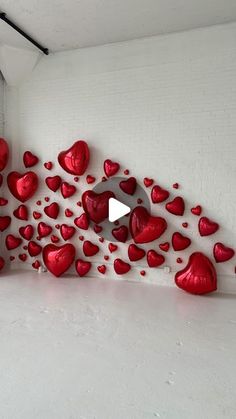 a white room with lots of red hearts on the wall and a video player in the corner