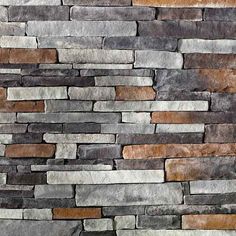 a stone wall that is made out of several different colors and shapes, including grey, brown