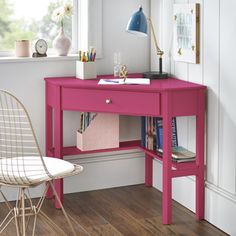 a pink desk with a chair next to it