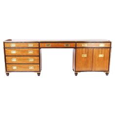 an antique wooden desk with drawers and brass handles