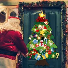 a man dressed as santa claus standing in front of a door decorated with christmas decorations