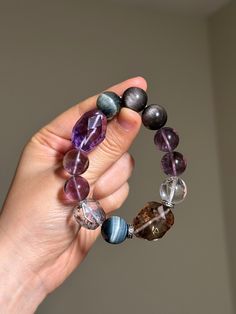 FREE SHIPPING on all US orders over $35 USD. Size: 13-16mm Material:  Amethyst, Phantom Quartz, Blue Tiger Eye, Silver Obsidian, Rock Crystal Quartz, 925 Sterling Silver Accessories Elevate your energy and style with my handcrafted gemstone bracelet! Only ONE availability - Order it now! You will receive the product as shown in the picture. This bracelet is suitable for wrist sizes  5.5 inches (14 cm). If your wrist size falls outside this range, please inform me your wrist size, and I will adjust the beads accordingly to fit your size. SIZE GUIDE: To ensure a perfect fit, accurate measurement of your wrist circumference is crucial. Use a measuring tape or a piece of string (which you can then measure with a ruler) to determine your wrist size. If you're purchasing the bracelet as a gift a Spiritual Rondelle Gemstone Beads Bracelets, Rondelle Natural Stones Beaded Bracelets For Healing, Healing Rondelle Beaded Bracelets With Natural Stones, Agate Gemstone Beaded Bracelets For Healing, Agate Bracelets With Polished Beads For Meditation, Adjustable Spiritual Crystal Bracelet With Polished Beads, Spiritual Rondelle Beaded Bracelets, Spiritual Beaded Rondelle Bracelets, Healing Gemstone Beads Stretch Bangle