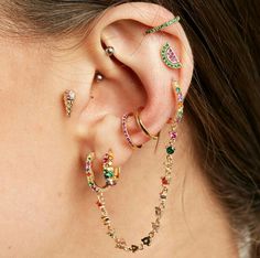 a close up of a person with ear piercings on their ears and wearing jewelry