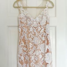 a dress hanging on a hanger in front of a door with a white background