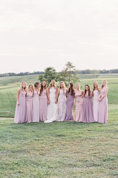 a group of women standing next to each other on top of a lush green field