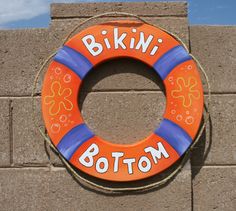 an orange and blue life preserver sitting on top of a brick wall