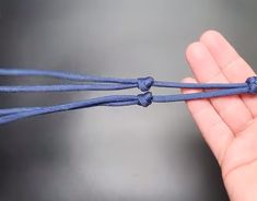 a hand holding a blue rope with two ends