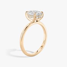 a yellow gold engagement ring with an oval cut diamond on the center and side stones