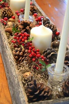 a wooden box filled with pine cones and candles