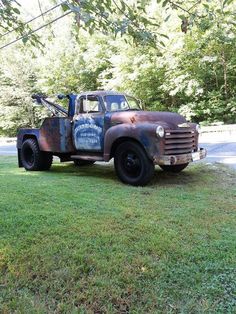 an old truck is parked in the grass