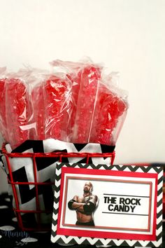 there are candy wrapped in plastic bags and on the table is a sign that says, the rock candy