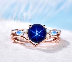 a blue ring with white stones in it on top of a bed of snowflakes