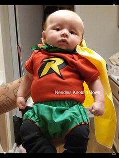 a baby in a costume is sitting on a chair