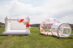 two inflatable balloons are set up on the grass for an outdoor wedding ceremony