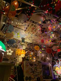 a room filled with lots of balloons and lights hanging from the ceiling over it's head