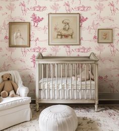 a baby's room with pink and white wallpaper, a teddy bear sitting in the crib