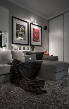 a living room filled with furniture and pictures on the wall next to a laptop computer