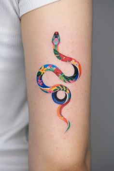 a colorful snake tattoo on the arm