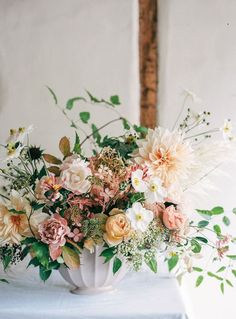 a vase filled with lots of flowers on top of a table