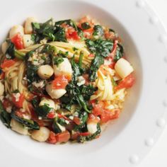 a white bowl filled with pasta and vegetables