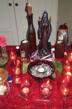 a table with candles, vases and other decorative items on top of the table