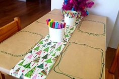 the table is set with markers and pencils for christmas tree themed placemats