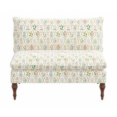 a white and green patterned couch with wooden legs