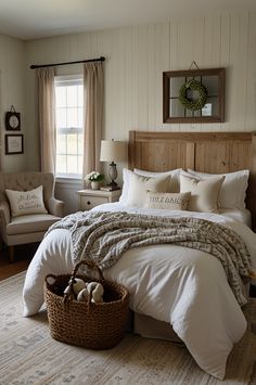 a large bed sitting in a bedroom next to two chairs and a table with a basket on it