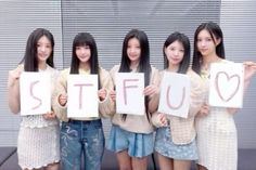 four girls holding up signs with the word stuff written on them in front of their faces