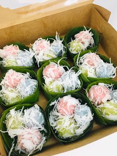 there are many different types of food in the cardboard box on the table, including rice balls