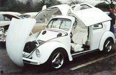 an old car with its doors open in a parking lot