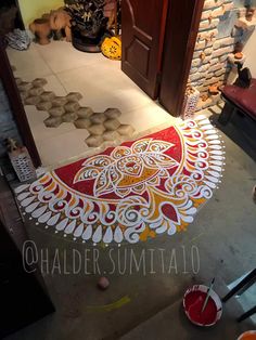 an intricately painted floor in front of a door and some pots on the ground