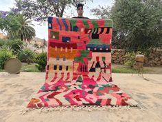 a man standing on top of a colorful rug