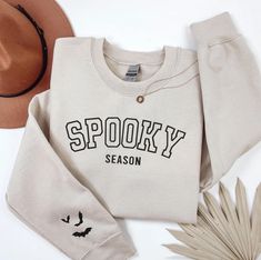 Embrace Autumn with our Embroidered Spooky season Sweatshirt complete with a bats on the sleeve too! This Halloween shirt is all embroidery, perfect to wear for Halloween. A must-have for cosy fashion lovers.  Check out more Halloween/Thanksgiving items here: https://www.etsy.com/shop/GrumpyGooseApparel?ref=seller-platform-mcnav&section_id=40090396 Browse through my other awesome items here: https://www.etsy.com/shop/GrumpyGooseApparel ABOUT THE PRODUCT: Unisex Heavy Blend™ Crewneck Sweatshirt | Cricut Fall Sweatshirt Ideas, Halloween Embroidery Sweatshirt, Halloween Embroidery Shirts, Cosy Fashion, Halloween Sweaters, Embroidered Halloween, Preppy Shirt, Halloween Sweater