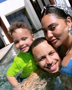 a woman and two children are in the water with their arms around each other as they smile at the camera