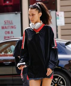 a woman walking down the street with headphones in her ears