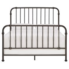 an iron bed frame with white sheets and beads on the headboard, in front of a