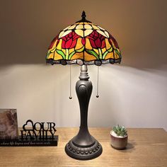 a lamp that is sitting on top of a table next to a potted plant